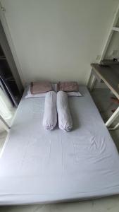 a large white bed with two pillows on it at Cozy Studio @Skyhouse BSD in Samporo