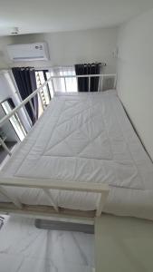 a bed in a room with a white mattress at Cozy Studio @Skyhouse BSD in Samporo