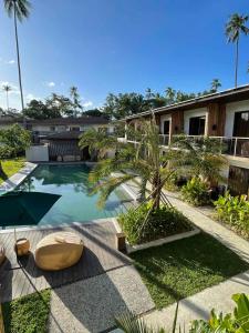 - une piscine avec un palmier à côté d'un bâtiment dans l'établissement Isla Amara Resort, à El Nido