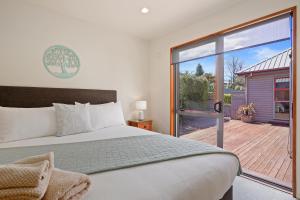 1 dormitorio con 1 cama y puerta corredera de cristal en Welcome Home - Hanmer Springs Holiday Home, en Hanmer Springs
