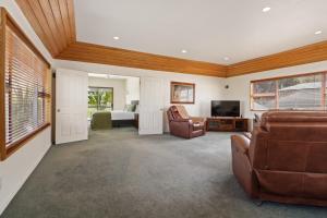 Sala de estar con sofá, cama y TV en Welcome Home - Hanmer Springs Holiday Home en Hanmer Springs