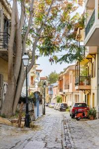 una calle en una ciudad con un árbol y un semáforo en PEARL STUDIO free private parking, en Tesalónica