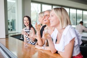 a group of people sitting at a bar drinking champagne at Junction Hotel in Newcastle