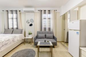 a bedroom with a bed and a couch and a table at PEARL STUDIO free private parking in Thessaloniki