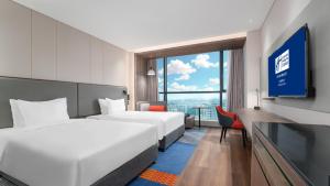Cette chambre comprend 2 lits et une télévision. dans l'établissement Holiday Inn Express Chengdu Pidu, an IHG Hotel, à Chengdu