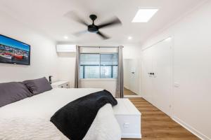 - une chambre avec un lit blanc et un ventilateur de plafond dans l'établissement Ray Bon, à Iluka