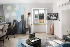 Erna in Labin - Istrien في لابين: شخص يمر بغرفة المعيشة مع جهاز كمبيوتر محمول على طاولة
