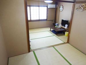 ein leerer Raum mit einer Tür und einem Tisch in der Unterkunft Imazato Ryokan - Vacation STAY 02545v in Osaka