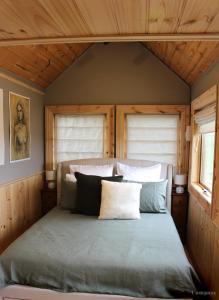 Cama en habitación con 2 ventanas en Compass Hut, en Melrose