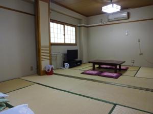ein leeres Zimmer mit einem Tisch in der Mitte in der Unterkunft Imazato Ryokan - Vacation STAY 02547v in Osaka + 3 Fotos