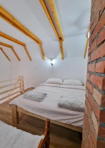 Bett in einem Zimmer mit Ziegelwand in der Unterkunft Vikendica Mihic in Zvornik