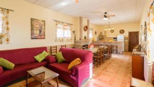 un soggiorno con divano rosso e tavolo di Vivienda Rural Pepe el del Aceite Trasmulas by Ruralidays a Granada