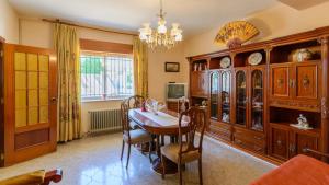 a dining room with a table and a chandelier at Vivienda Rural Pepe el del Aceite Trasmulas by Ruralidays in Granada