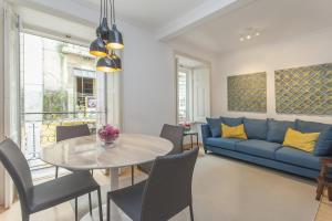ein Wohnzimmer mit einem blauen Sofa und einem Tisch in der Unterkunft Your Lisbon Home Bairro Alto in Lissabon