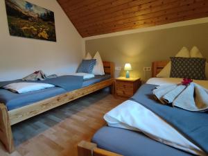 a bedroom with two beds and a wooden ceiling at Landhaus Seebacher in Spital am Pyhrn
