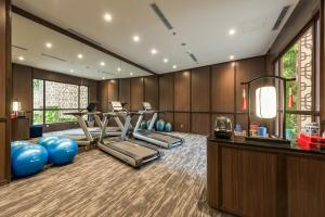 a gym with treadmills and exercise equipment in a room at Ashley Tang Menteng Jakarta in Jakarta