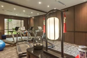 a gym with exercise equipment and a large light fixture at Ashley Tang Menteng Jakarta in Jakarta