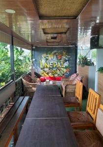 a long table and chairs in a restaurant at The Glasshouse Hotel in Kawasoti