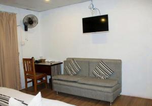 a living room with a couch and a table at The Glasshouse Hotel in Kawasoti