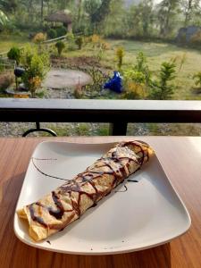a piece of food on a white plate on a table at The Glasshouse Hotel in Kawasoti