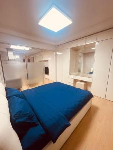 um quarto com uma grande cama azul num quarto em Happy Days at Highvill G em Promyshlennyy