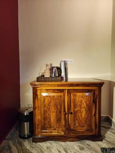 un armario de madera con una cafetera encima en The Hidden Tribe, en Bīr