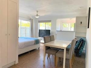 1 dormitorio con cama, escritorio y mesa en Broadwater Keys Holiday Apartments en Gold Coast