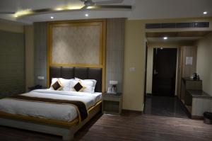 a hotel room with a bed and a bathroom at Tulip Tree Hotel in Katra
