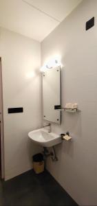 y baño con lavabo blanco y espejo. en Jaffer Bhai's Brickland Hotel, en Panchgani
