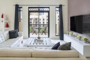 un soggiorno con divano e una grande finestra di Zaafaran Tower 2 - 2BR Apartment - Allsopp&Allsopp a Dubai