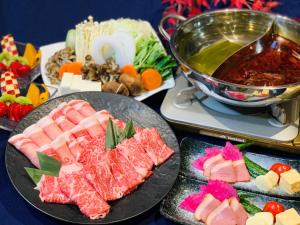 a table topped with plates of sushi and meat at Yugashima Golf Club & Hotel Resort in Izu
