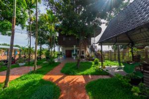 un giardino con passerella in mattoni di fronte a una casa di The Green Home a Siem Reap
