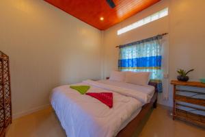 um quarto com uma cama com duas almofadas vermelhas em The Green Home em Siem Reap