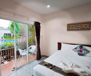 a bedroom with a bed and a balcony at Baanloksouylokchay in Hua Hin