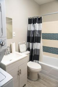 a bathroom with a toilet and a sink and a shower at Lincoln Manor - Newly Renovated, 1mile from PHL Airport and Sports Stadiums in Prospect Park +30 photos