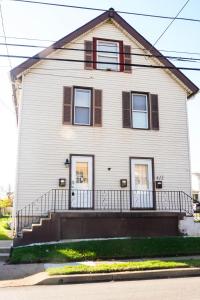 una casa blanca con una escalera delante en Lincoln Manor - Newly Renovated, 1mile from PHL Airport and Sports Stadiums en Prospect Park