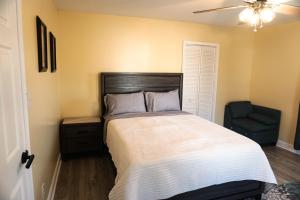 a bedroom with a large bed and a chair at Lincoln Manor - Newly Renovated, 1mile from PHL Airport and Sports Stadiums in Prospect Park