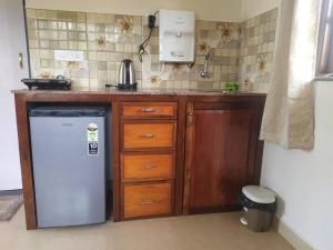 a kitchen with a refrigerator and wooden cabinets at Palmeiral BeachVilla in Calangute