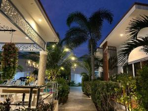 a house with a courtyard with palm trees and a restaurant at Baanloksouylokchay in Hua Hin
