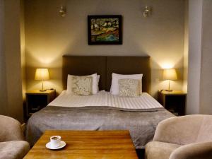 a bedroom with a bed and two chairs and a table at Boutique Hotel Amra in Sukhum