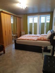 a bedroom with a bed in a room with windows at Ferienwohnung Holzmann in Wernigerode