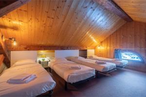 Un grupo de 4 camas en una habitación con techos de madera en La Chapelle Aux Pieds Des Pistes en Chamonix-Mont-Blanc