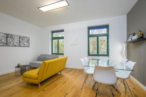 een woonkamer met een gele stoel en een glazen tafel bij Arbio I Modern Apart near Leipzig Stötteritz in Leipzig