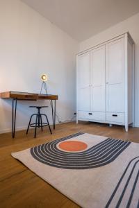 een kamer met een bureau en een tapijt op de vloer bij Arbio I Modern Apart near Leipzig Stötteritz in Leipzig