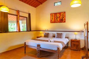 una camera da letto con un letto grande in una stanza di StayVista at Firefly By The River with Breakfast a Kushalnagar