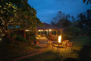 un tavolo e delle sedie davanti a un edificio di notte di StayVista at Firefly By The River with Breakfast a Kushalnagar