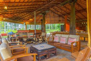 an outdoor living room with chairs and a table at StayVista at Firefly By The River with Breakfast in Kushālnagar
