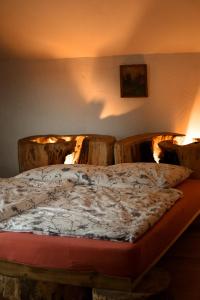 a bed in a room with two wooden chairs at Rajska Willa in Rajcza