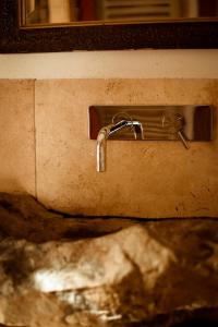 a bathroom sink with a faucet on a wall at Rajska Willa in Rajcza