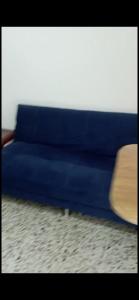 un sofá azul sentado sobre una alfombra en Apartmanto simple para descansar floresta, en Medellín